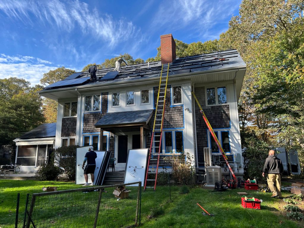 Whaling City Solar technicians carefully installing custom-designed solar panels on a Cape Cod residence, demonstrating our professional installation process